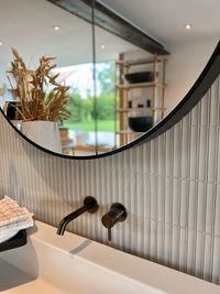 Detailansicht von Wandspiegel und modernen Fliesen bei bad und zimmer concept