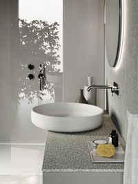 Marmor Waschbecken mit Regal und Glasduschkabine im Hintergrund - Luxuriöses Baddesign von bad und zimmer concept